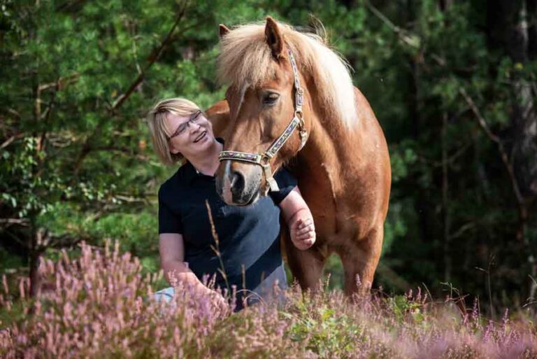 Frau mit Pferd in Heideumgebung
